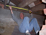 Technician measuring basement rafters