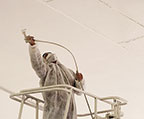 Technician spraying ceiling with foam